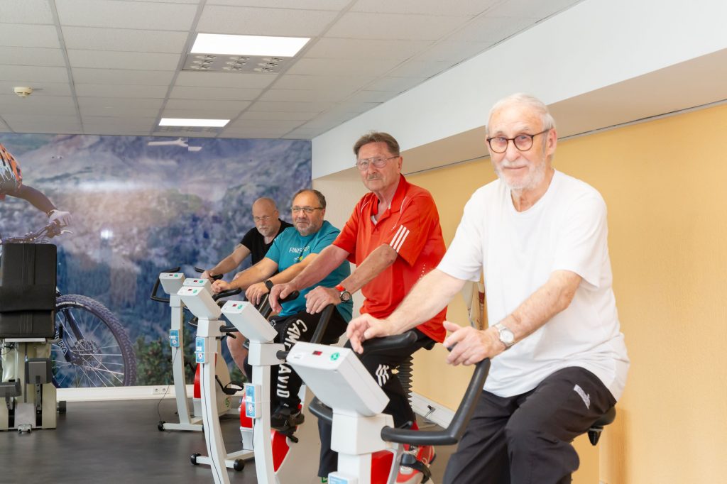 Eine Gruppe übt in der Reha-Fachklinik auf Hometrainern.